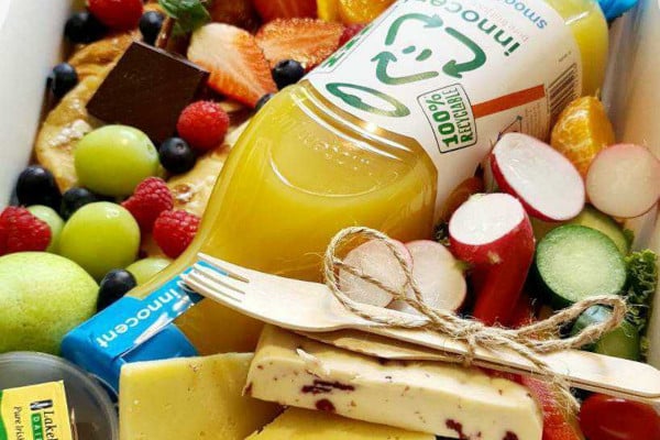 Box filled with snacks, fruit, and juice
