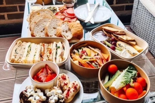 Picnic foods in takeaway packaging on a table