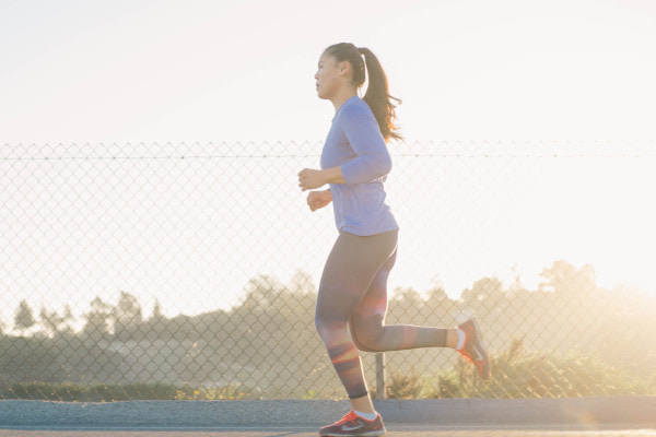 Woman running with the sun shining