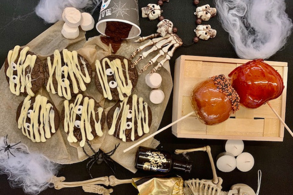 Halloween-themed cookies and candy apples