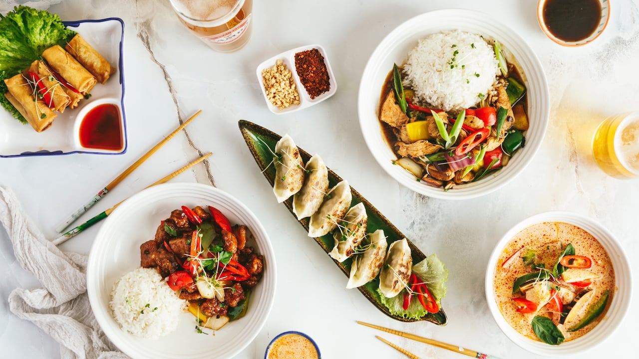 Colleagues choosing Thai, Chinese and salad dishes for a team lunch