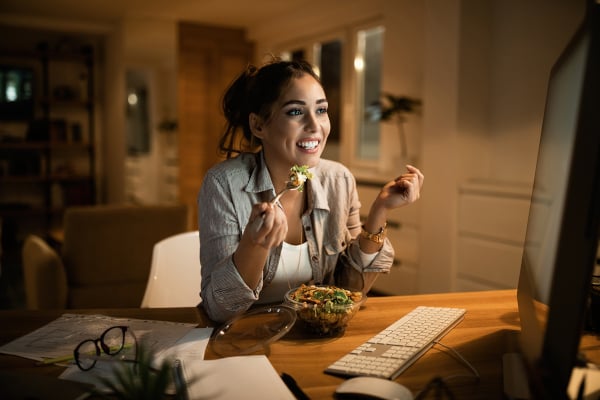 WomanEatingAtDesk