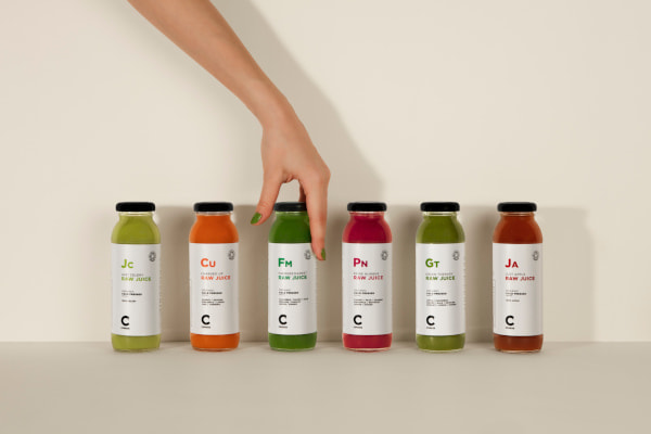 Hand reaching for glass bottle of green juice