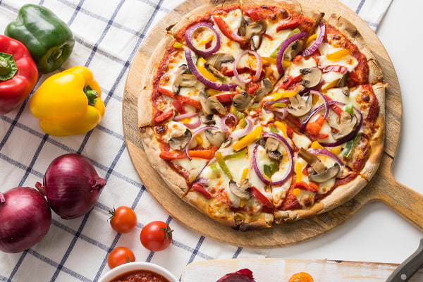 Veggie pizza on a wooden serving board