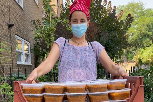 Person holding up lots of meals for schools