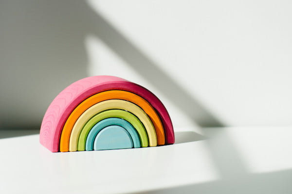 Wooden rainbow decoration on a white shelf