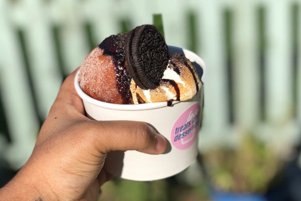 Hand holding out donut sundae