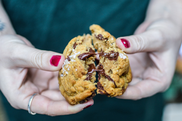 hands breaking apart vegan cookie