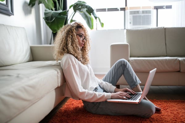 woman on laptop sitting on the floor